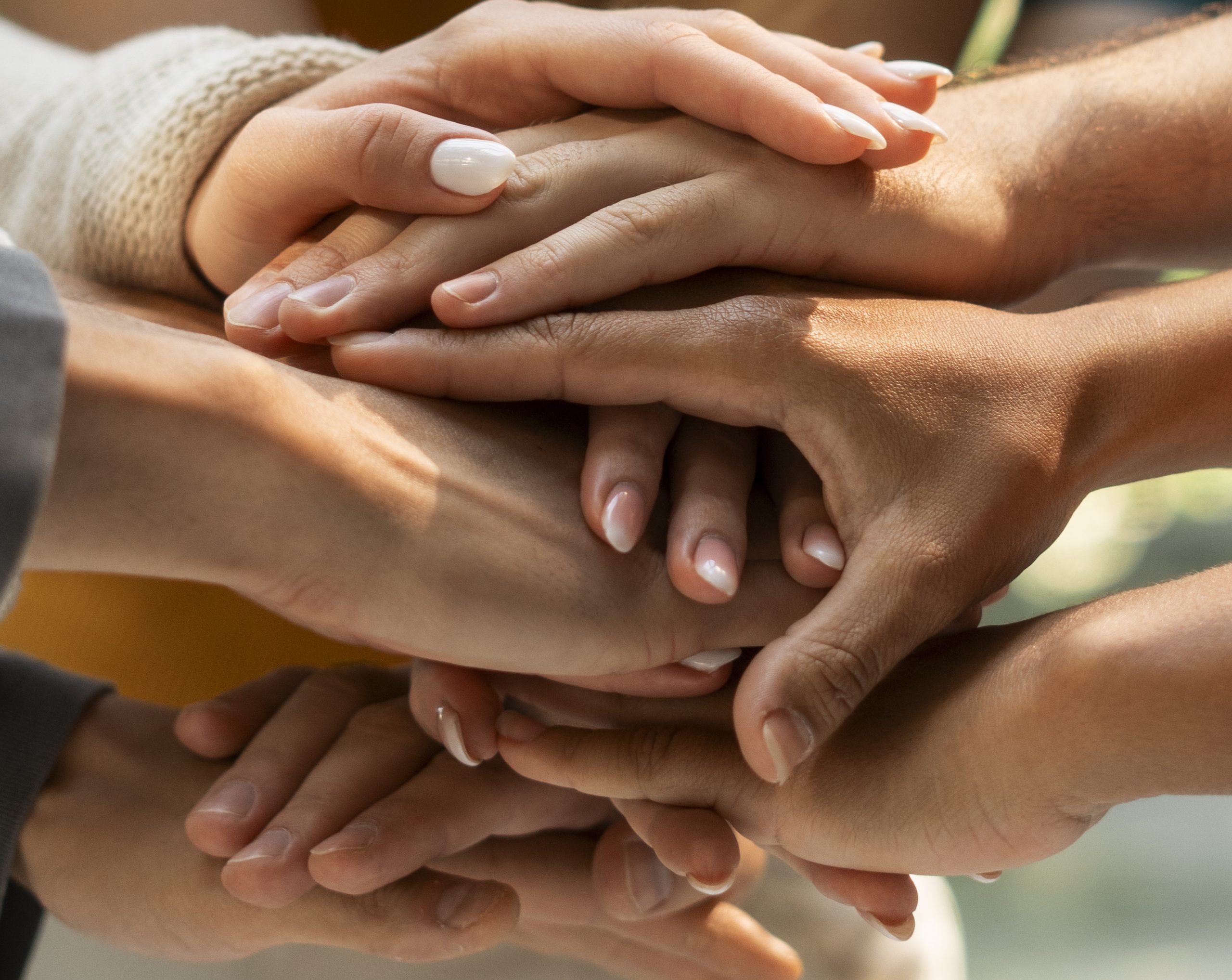 Manos unidas de un equipo de trabajo en actividad de desarrollo de equipos, trabajo colaborativo y team building en empresas.